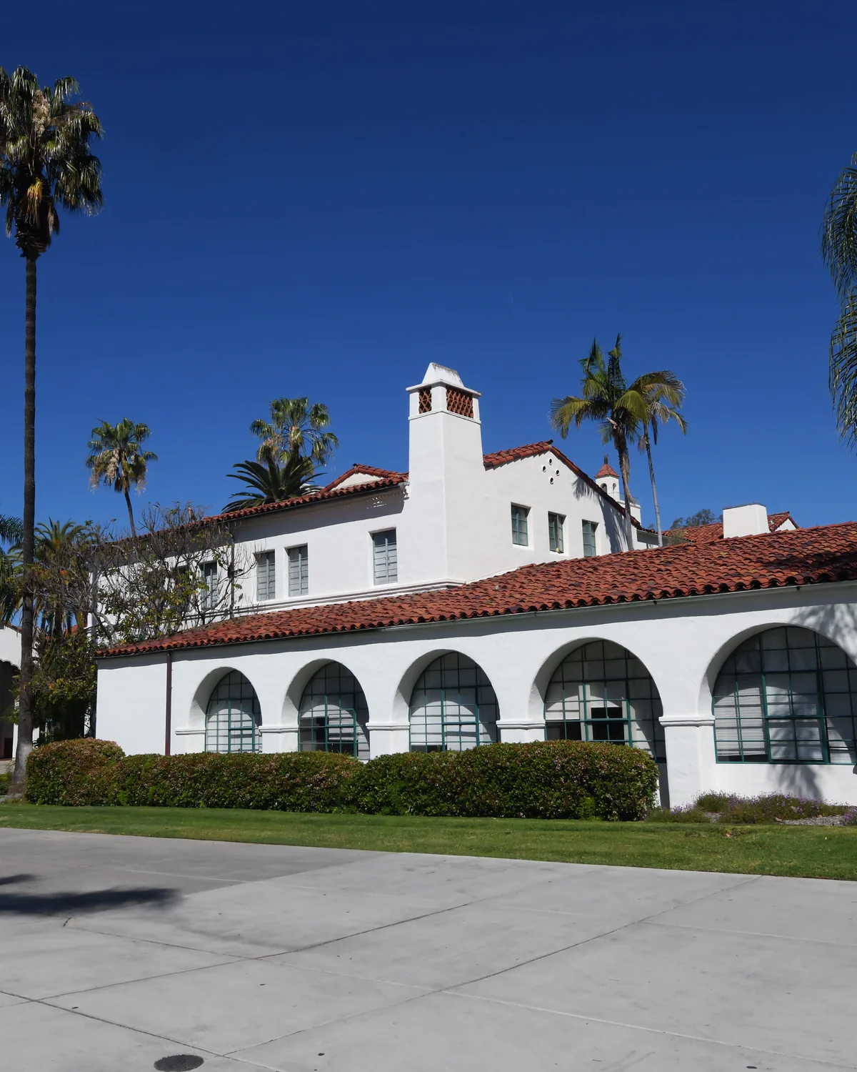 White stucco architecture with red tile and palm trees